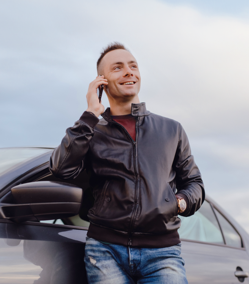 Hombre adulto sonriente manejando su auto